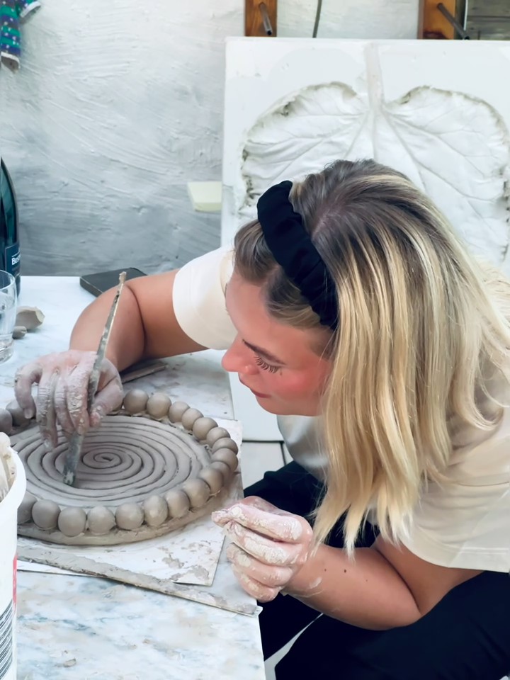 A young women hands on clay making a piece of ceramics.